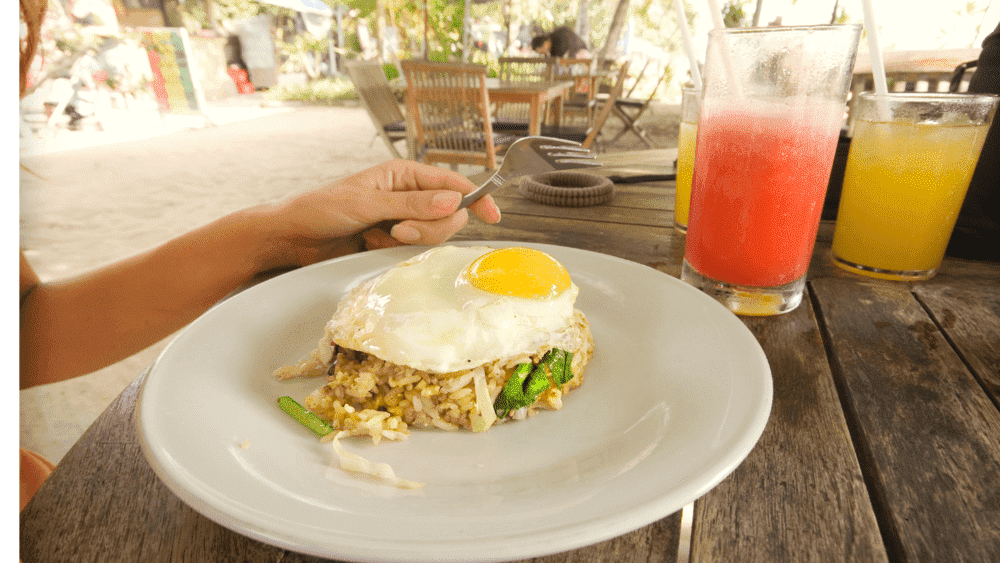 Nasi Goreng: Este prato indonésio de arroz frito é um alimento básico em Bali. É tipicamente servido com um ovo estrelado por cima e acompanhado por bolachas de camarão e pickles.